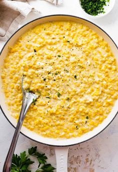 a skillet filled with macaroni and cheese, garnished with parsley