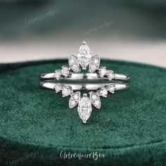 a diamond ring sitting on top of a green velvet box