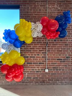 balloons are arranged in the shape of a heart on a brick wall near a window