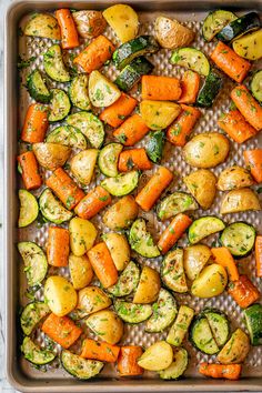 roasted carrots, potatoes and zucchini on a baking sheet in a roasting pan