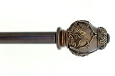 a close up view of a wooden handle on a curtain rod with an ornate design