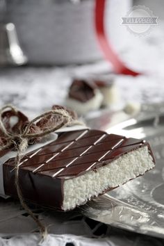 a piece of chocolate and marshmallows on a silver plate with a red ribbon