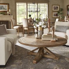 a living room with couches, chairs and a table in front of a fireplace