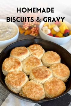 homemade biscuits and gravy in a cast iron skillet with bowls of fruit