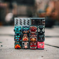 a group of colorfully decorated cell phones sitting on top of each other in front of a building