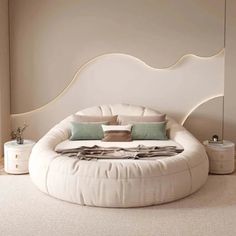 a large round bed in a bedroom with white walls and flooring, along with two nightstands