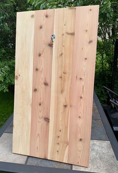 two wooden boards sitting on top of a cement slab in front of some trees and bushes