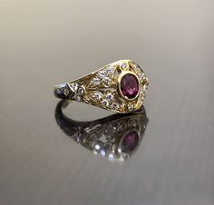 DeKara Designs Collection Metal- 18K Yellow Gold, .750. Stones- 1 Oval Ruby 0.50, 28 Round Diamonds G Color VS2 Clarity 0.22 Carats. Art Deco 18K Yellow Gold Ruby Diamond Engagement Ring. This ring features a beautiful reddish pink ruby that is half carat total weight, surrounded by 28 round diamonds. The center ruby is bezel set, 20 pave set diamonds, and 8 bezel set diamonds. The ring is entirely handmade, and could be hand engraved for an additional $200.00. The ring is a size 6 1/2, and coul Traditional Yellow Gold Ruby Ring For Anniversary, Gold Ruby Ring With Intricate Design For Anniversary, Anniversary Gold Ruby Ring With Intricate Design, Yellow Gold Hallmarked Ruby Ring For Wedding, Hallmarked Yellow Gold Ruby Ring For Wedding, Heirloom Gold Ruby Ring With Rose Cut Diamonds, Heirloom Ruby Ring With Rose Cut Diamonds In Gold, Traditional Yellow Gold Diamond Ring For Anniversary, Yellow Gold Sapphire Ring With Intricate Design For Wedding