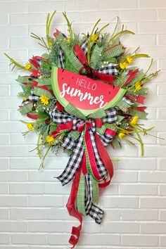 a watermelon wreath with the words hello summer hanging on a white brick wall