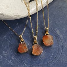 So simple and so cool with an earthy boho vibe! Absolutely gorgeous and and one-of-a-kind genuine carnelian crystals are set in a 14k gold plated bezel. The back of the setting is open to allow light to shine through these beautiful stones. . Each pendant is made from genuine carnelian and set by hand so no two are exactly alike. Soulful, earthy, and oh so cool.Carnelian is a birthstone for August and the zodiac sign Virgo.*Choose your chain- Options for 16" satellite chain with extender, 16" bo Gold Agate Wire Wrapped Necklace, Gold Agate Healing Jewelry, Gold Agate Wire Wrapped Jewelry, Gold Agate Jewelry For Healing, Gold Agate Gemstone Jewelry, Adjustable Gold Carnelian Necklace, Adjustable Gold Chalcedony Jewelry, Earthy Gold Jewelry With Gemstones, Brown Carnelian Gemstone Necklaces