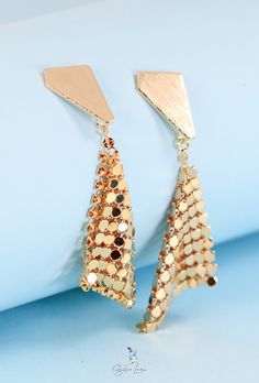 Make way for a statement like no other. These sparkling gold plated drop earrings instantly elevate any look with geometric sparkle that dances in the light. Crafted from gold plated brass for a high shine that lasts, the triangular studs frame a shimmering handkerchief design that will have heads turning. Trendy Gold Triangle Earrings, Triangle Gold Metal Earrings, Gold Triangle Metal Earrings, Geometric Gold Earrings For Party, Gold Geometric Earrings For Party, Gold Geometric Jewelry For Party, Diamond-shaped Gold Jewelry For Party, Gold Diamond-shaped Party Jewelry, Handkerchief Design