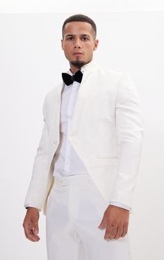 DETAILS This white tailored fit tuxedo is a unique and stylish option for any special or formal event. Features a raised laced texture of the fabric that creates depth and dimension, adding a tactile element to the jacket. Designed with a mandarin collar. which adds a touch of modernity to the jacket. As well as having a satin finish around the closure, giving a luxurious sheen to the outfit. Pair with any Tomson Tuxedo Pants SIZE + FIT Tailored fit, to find your correct size use the ''What's my Elegant Fitted Spring Tuxedo, Luxury Spring Wedding Suits, Tailored White Tuxedo For Party, White Long Sleeve Tuxedo For Party, White Notch Lapel Blazer For Groom, Elegant Semi-formal Spring Tuxedo, White Long Sleeve Semi-formal Tuxedo, Elegant Spring Semi-formal Tuxedo, White Spring Semi-formal Tuxedo