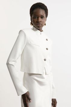 Increase The Formality In Our Cropped Jacket, Which Features A Full-Coverage High Neckline To Protect From The Elements, As Well As A High Collar And A Slightly Cropped Length. Style It With Tailored Trousers And Pointed Toe Heels For A Statement Occasion Look, Perfect For Cool Days That Require An Elevated Look. Button Detail Luxe Ponte Jersey Cropped Jacket Formal High Neckline And Collar Fitted Silhouette Unique Asymmetric Button Detailing Cropped Length Beige Cropped Jacket With Button Cuffs For Work, White Button-up Cropped Jacket For Fall, White Blazer With Button Cuffs For Work, Fitted White Button-up Cropped Jacket, White Fitted Button-up Cropped Jacket, Elegant Single Breasted Button-up Cropped Jacket, White Long Sleeve Cropped Jacket With Button Closure, White Cropped Jacket With Button Closure And Long Sleeves, White Cropped Jacket With Button Closure