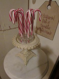 some candy canes are in a glass vase