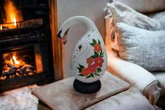 a white vase sitting on top of a table next to a fire place