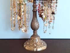 a lamp that has many necklaces hanging from it's sides and is on top of a table