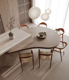 a wooden table with chairs around it in front of a wall mounted vase and lamp