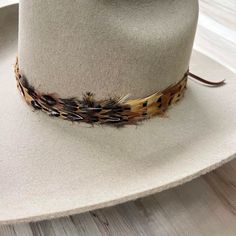 Natural feather hat band. Adjustable with a leather tie. Natural colored feathers Adjustable hatband Approx. 1 inch wide *This product is for 1 single hat band. Hat not included. Rustic Adjustable Brown Top Hat, Adjustable Brown Hat Band For Country Events, Adjustable Brown Hats For Hunting, Adjustable Top Hat For Country Events In Fall, Adjustable Brown Top Hat For Fall, Adjustable Flat Brim Felt Hunting Hat, Adjustable Flat Brim Felt Hat For Hunting, Rustic Adjustable Hat For Hunting, Adjustable Brown Top Hat For Ranch