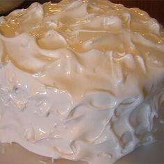 a cake with white frosting sitting on top of a table