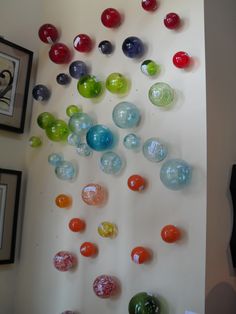 there are many different colored glass balls on the wall