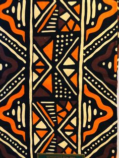 an orange, black and white design on a piece of cloth