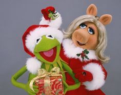 the muppet and miss piggy are dressed up as santa claus, holding a present