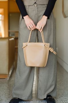 Dress up or keep it casual with the Miriam crossbody bucket bag. Designed with a handle that knots at the side of the opening. The interior features a slot and zip pocket to keep your belongings neatly organized and secured. Includes an adjustable and removable crossbody strap. Versatile Beige Crossbody Bucket Bag, Chic Crossbody Bucket Bag With Zipper Closure, Versatile Top Handle Beige Bucket Bag, Versatile Beige Top Handle Bucket Bag, Versatile Beige Bucket Bag With Top Handle, Bucket Satchel With Top Carry Handle For On-the-go, Modern Bucket Bag With Zipper Closure For On-the-go, Versatile Rectangular Bucket Bag With Handle Drop, Casual Bucket Box Bag With Detachable Strap