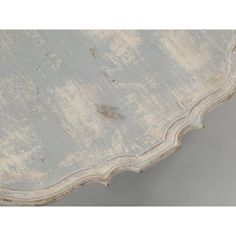 an old white table with peeling paint on it