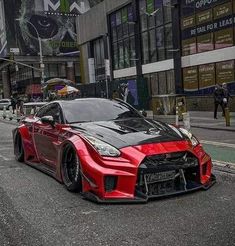 a red and black sports car parked on the street