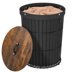 a black trash can next to a wooden lid