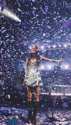 a woman standing on top of a stage surrounded by confetti