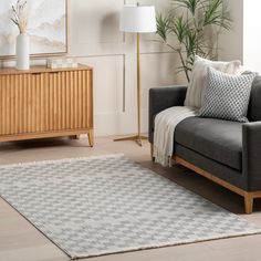 a living room with a gray couch and white rug