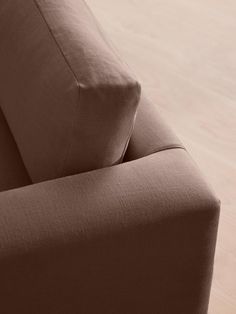 a close up view of the back end of a couch with wood floors in the background