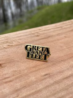 a close up of a wooden surface with a metal pin on it that says, great way to fly