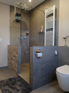 a bathroom with a shower, toilet and sink in it's center wall area