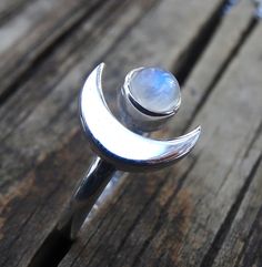 Handmade, Natural Rainbow Moonstone Sterling Silver Ring 💙Featured in this listing are sterling silver, handmade, natural stone rings. These lovely rings feature a beautiful, Natural Rainbow Moonstone 7mm round stone. The Glowing stone has been bezel set into a handcrafted, adjustable setting made with all highly polished Sterling Silver. A handcrafted Crescent Moon sits aside the Moonstone and is 11x15mm. Each Rainbow Moonstone has been handpicked, and have amazing flash! 🌜Please keep in mind Crescent Moonstone Ring For Anniversary, Crescent Moonstone Anniversary Ring, Celestial Moonstone Ring With Moon Charm, Celestial Moonstone Ring With Moon Charm As Gift, Silver Moonstone Ring With Moon Phase, Silver Moonstone Ring With Moon Charm As Gift, Crescent Moonstone Promise Ring, Silver Moonstone Crystal Ring In Moon Shape, Crescent Moonstone Ring For Gift