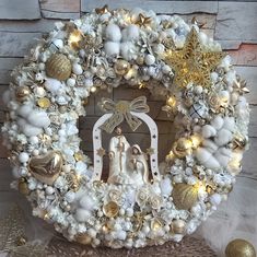 a christmas wreath with white and gold decorations