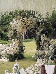 an outdoor ceremony with white flowers and greenery