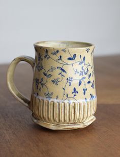 a blue and white cup sitting on top of a wooden table