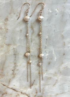 Lightweight, effortless elegance. These long, freshwater pearl, 14kt GF Chain earrings are perfect bridal earrings or an effortlessly chic look for any event. Elegant Long Drop Pearl Pendant Earrings, Elegant Dangle Pearl Chain Earrings, Elegant Pearl Chain Dangle Earrings, Elegant 14k Gold Filled Pearl Drop Earrings, Elegant Long Drop Pearl Chain Bridal Earrings, 14k Gold Dangle Linear Earrings With Pearl Drop, Elegant Long Drop Pearl Earrings With Pearl Charm, 14k Gold Drop Pearl Earrings With Pearl Chain, Dangle Pearl Earrings With Pearl Chain