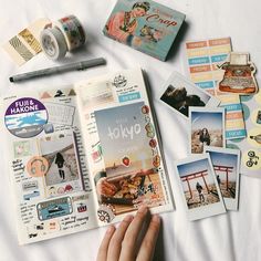 an open book with pictures and stickers on top of it next to a person's hand