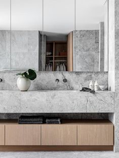 a bathroom with marble counter tops and large mirrors on the wall, along with two sinks