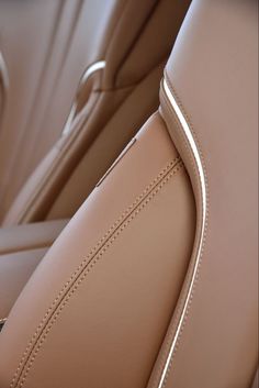 the interior of a car with beige leather and stitching on the front dash board