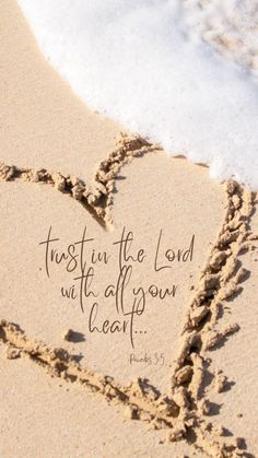 a heart drawn in the sand with a bible verse