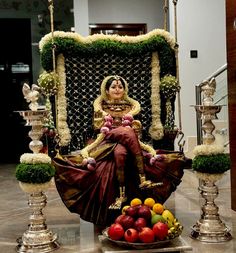 a woman sitting in a chair with fruit on the floor