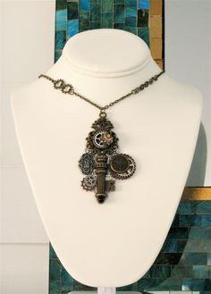 Steampunk Necklace, handmade by Ralston Originals. This Steampunk necklace started with a large antique silver filigree piece, I added many steampunk embellishments, including; a large antique gold skeleton key with a crown top design, an antique gold metal clock face charm, antique silver metal lock charm, a small glass cabochon with steampunk gear design, and silver, and copper metal steampunk gears. The necklace chain is antique gold metal, with steampunk gears. This Steampunk necklace is 16 Steampunk Metal Jewelry Vintage Collection, Steampunk Jewelry With Vintage Charm, Steampunk Silver Brass Necklaces, Steampunk Jewelry With Antique Metal Finish, Steampunk Silver-color Brass Necklaces, Steampunk Metal Jewelry With Antique Finish, Steampunk Gold Necklace For Vintage Collection, Silver Steampunk Brass Necklaces, Gold Steampunk Necklace Vintage