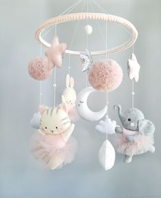 a baby mobile with stuffed animals hanging from it's sides and balls in the air