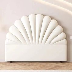 a large white shell shaped bed sitting on top of a wooden floor next to a wall