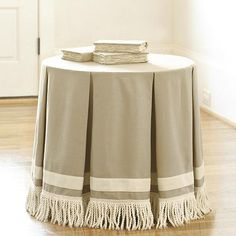 a round table with a tasseled edge and two napkins on the top