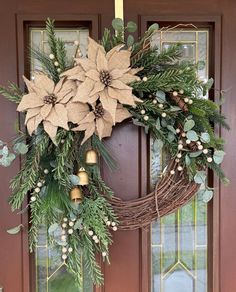 a wreath with poinsettis and greenery hangs on the front door